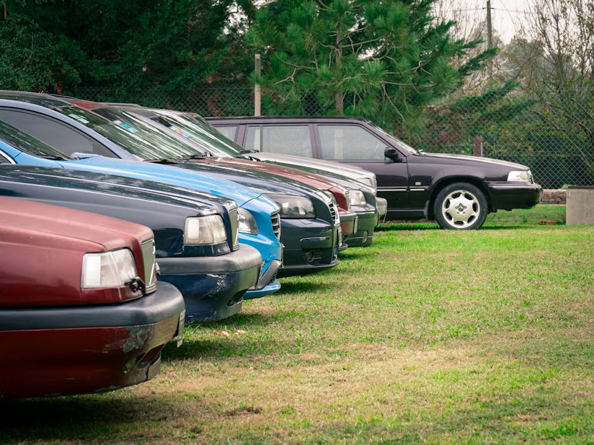 A row of cars parked in a field#$